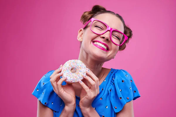 Linda hembra sonriendo mientras sostiene una rosquilla sabrosa —  Fotos de Stock