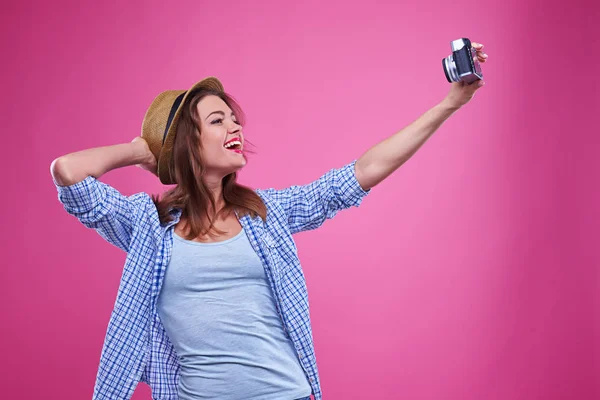 Flicka poserar för att göra en selfie via retro kamera — Stockfoto