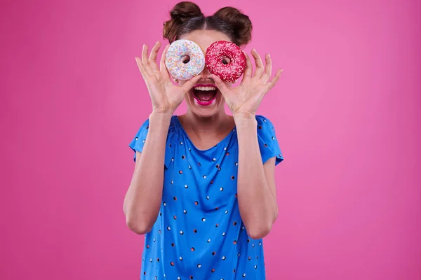 Feliz mulher olhando através de dois donutnuts polvilhados — Fotografia de Stock