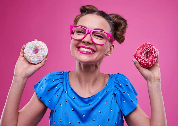 Rident mulher mostrando donuts polvilhados — Fotografia de Stock