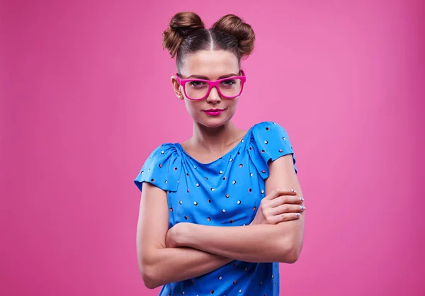 Ragazza snella in occhiali rosa con le mani incrociate sul retro rosa — Foto Stock