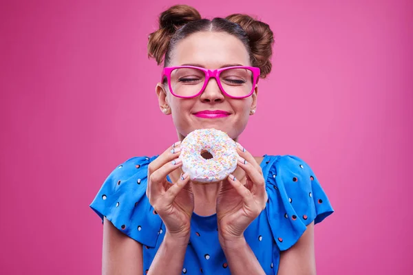 Sourire fille caucasienne avec les yeux fermés tenant un beignet — Photo