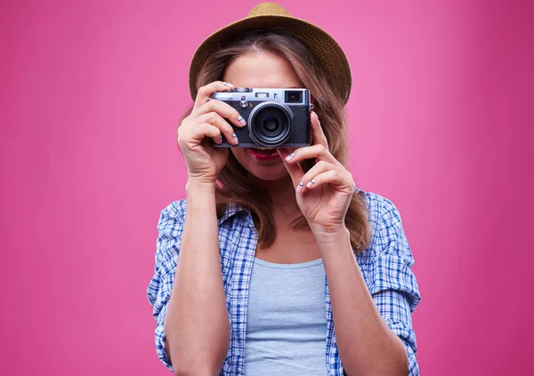 Молодая девушка фотографируется с серебряной камерой — стоковое фото