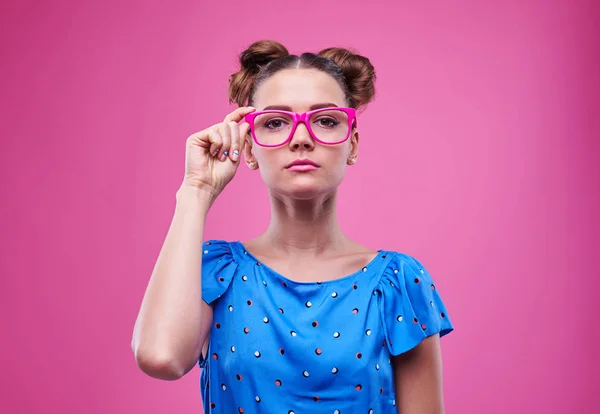 Fiatal nő, súlyos arc expressio rózsaszín szemüveg — Stock Fotó