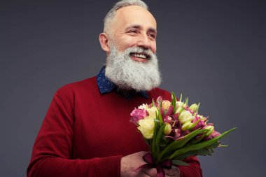 Bir buket bahar Lale ile üst düzey sakallı adam yan görünüm