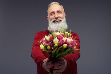 Bir bouq ile kırmızı kazaklı bir sakallı pozitif orta yaşlı adam