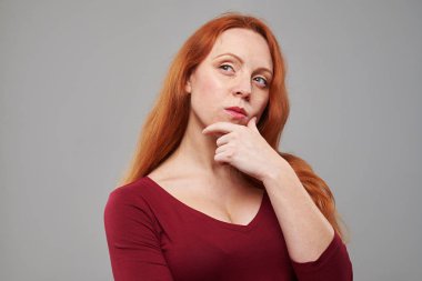 El çene üzerinde tutan düşünceli genç Kızıl saçlı kadın 
