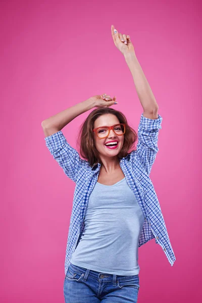 Zufriedene Mädchen tanzen isoliert über rosa Hintergrund — Stockfoto