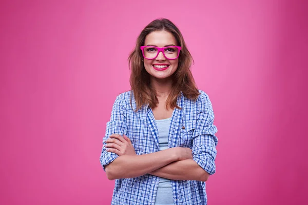 Begeisterte junge Frau mit Brille und verschränkten Armen — Stockfoto
