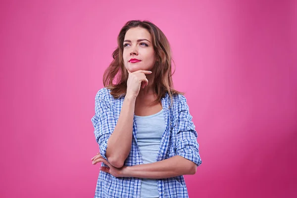 Curious young woman thinking with finger at a chin — Stock Photo, Image