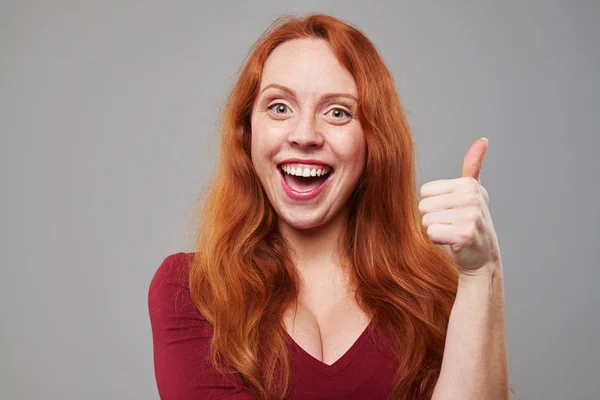 Mulher alegre com cabelo de auburn segurando gesto ok — Fotografia de Stock