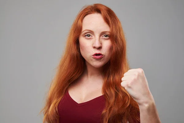 Confiante jovem ruiva mostrando um punho — Fotografia de Stock