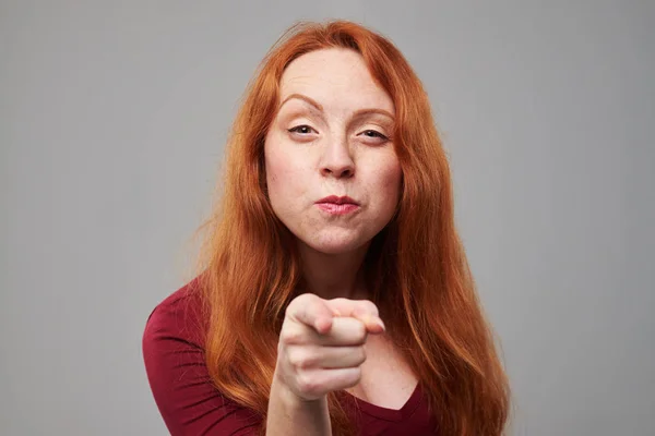 Young redhead woman pointing with an index finger at you — Stock Photo, Image