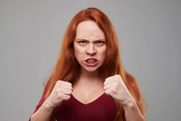 Agresivní žena s nazrzlé vlasy stojící v ochranném představují wi — Stock fotografie