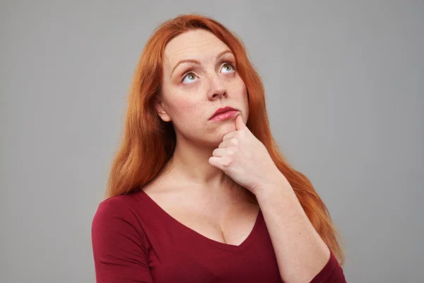 Nadenkend roodharige vrouw naar boven op zoek naar een kopie ruimte — Stockfoto