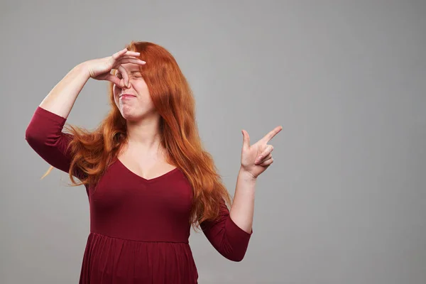 Mulher ruiva grávida segurando nariz fechado por causa do mau cheiro — Fotografia de Stock