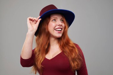 Yukarı doğru bir kopya alanı için seyir şapka meraklı Kızıl saçlı kadın 