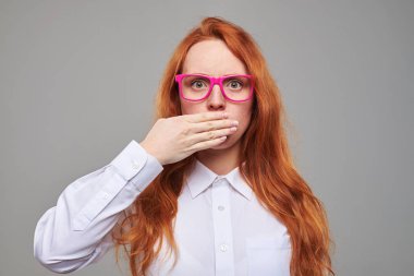 Hayret Kızıl saçlı kız bir el ile ağız kapalı