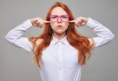 Uzun saçlı kumral genç kız işaret parmakları kulaklarını yapışmasını