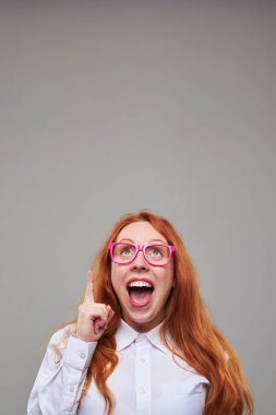 İşaret parmağı tutarak harika bir fikir ile neşeli kız