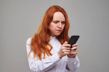 Kumral saçlı tel ekranında işaret eden asabi kız