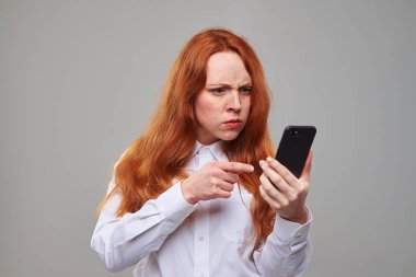 Telefon ekranında işaret kızgın Kızıl saçlı kız 