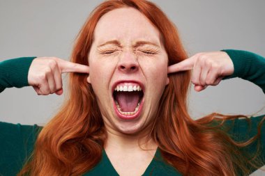 Tahriş olmuş genç kadın parmakları ile kulakları tıkalı