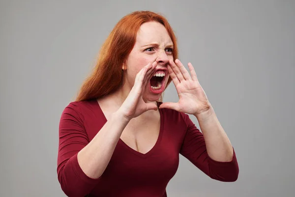 Злая рыжая молодая женщина громко кричит — стоковое фото