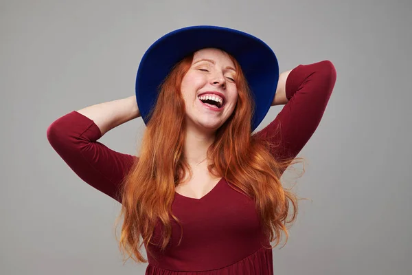 Unbekümmerte junge Frau mit kastanienbraunem Haar im Hut und Händchen haltend — Stockfoto