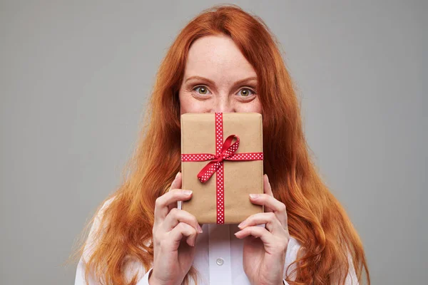Pelirroja chica mira hacia fuera la caja de regalo —  Fotos de Stock