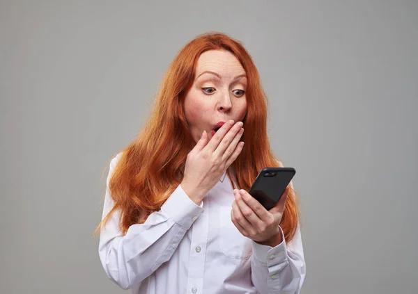 Amazed redhead girl covering mouth with hand in a surprise — Stock Photo, Image