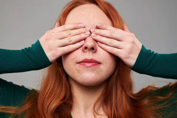 Young woman closes eyes with two hands — Stock Photo, Image