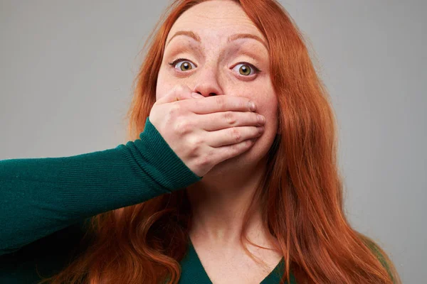 Assustado jovem ruiva cabelo mulher cobrindo sua boca com a mão — Fotografia de Stock