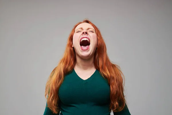 Loudly screaming redhead woman expressing negative emotions — Stock Photo, Image