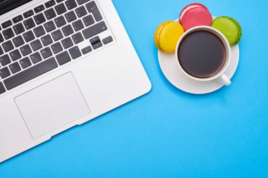 Çalışma alanı ile bir dizüstü bilgisayar ve kahve içerken mavi flatlay