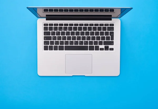 Modern silver laptop lying on the blue flatlay with a place for — Stock Photo, Image