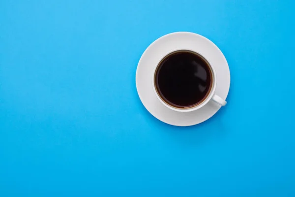 High angle of an aroma cup of coffee over blue flatlay with a co — Stock Photo, Image