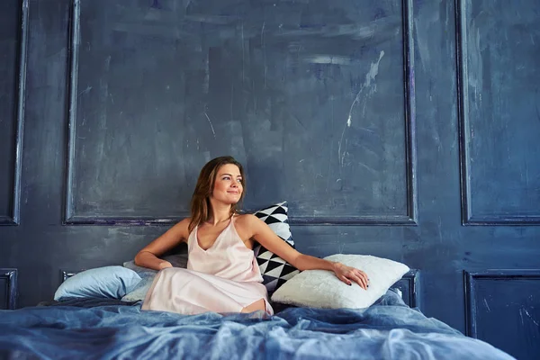 Morena relajada mirando a la ventana después de despertar — Foto de Stock