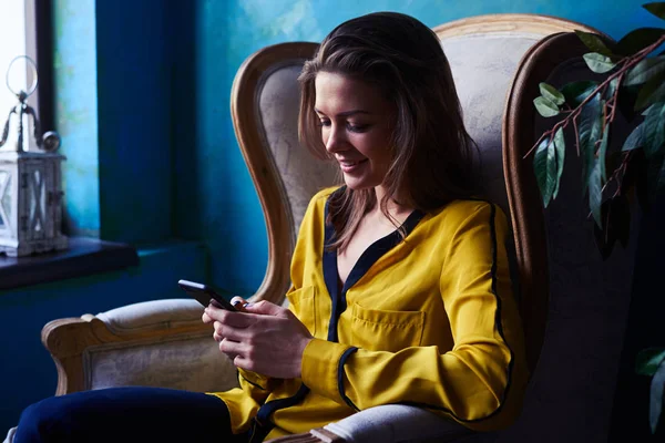 Kaukasiska flicka skicka meddelande medan du sitter bekvämt — Stockfoto