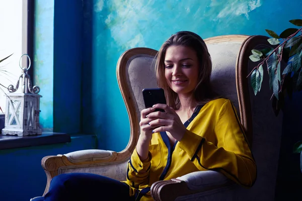 Chica elegante escribiendo en un teléfono móvil un mensaje —  Fotos de Stock