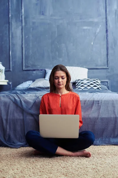 Geconcentreerde vrouw bezig met de laptop op de verdieping — Stockfoto