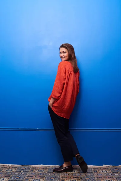 Smiling brunette half-turned posing isolated in the studio — Stock Photo, Image