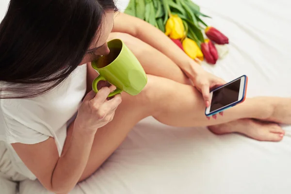 Kopfschuss einer Frau, die Tee aus einer Tasse trinkt, während sie auf — Stockfoto