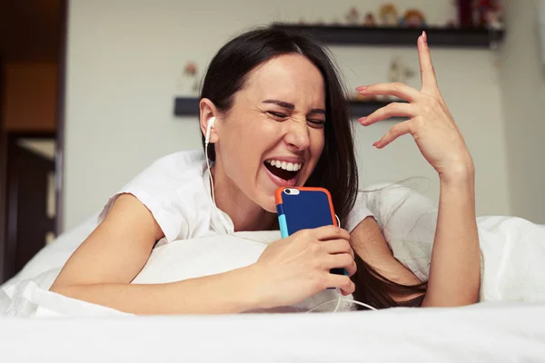 Espressiva femminile che canta al telefono mentre ascolta il mu — Foto Stock