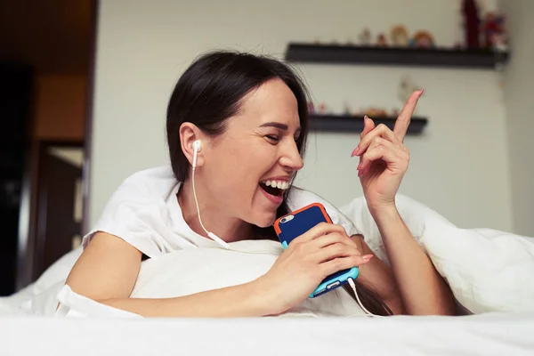 Enthusiastic female singing in phone while listening to the musi — Stock Photo, Image