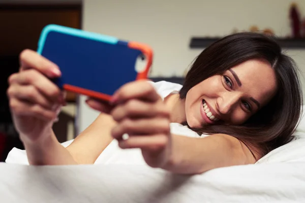 Bruna attraente fare un selfie nel letto — Foto Stock