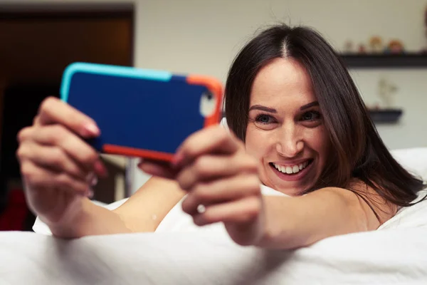 Vacker kvinna med en naturlig makeup ser att göra selfie — Stockfoto