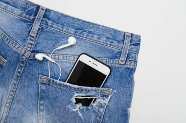 Bir yırtık kot şort telefon ve kulaklık ile düz lay