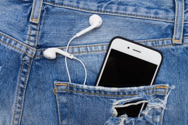 Cebinde telefon ve kulaklık ile kot şort sökük,