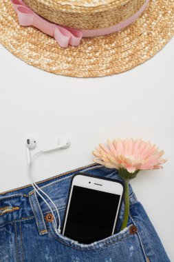 Hasır şapka ve kot pantolon cebinde, düz yatıyordu bizdeki telefon ile